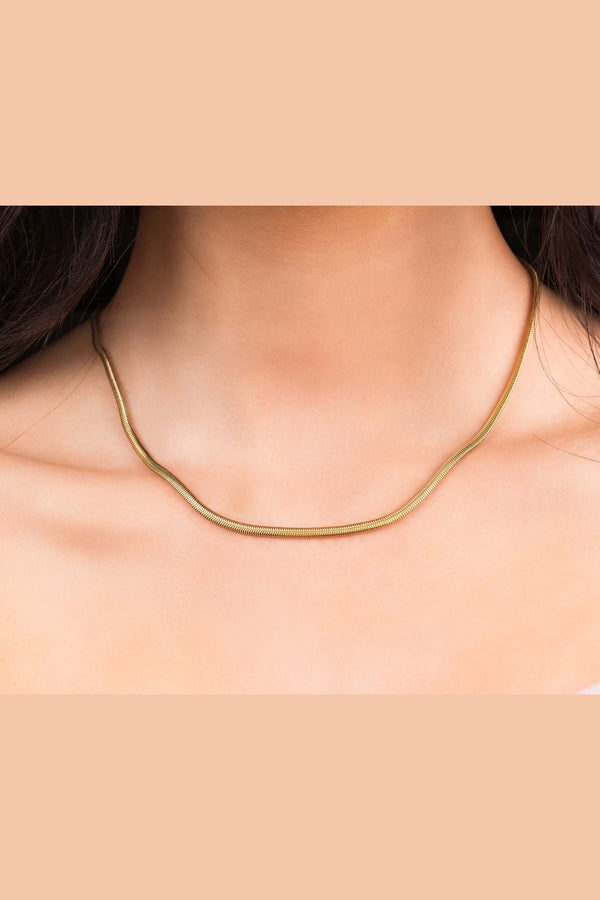 Elegant Alina Gold Herringbone Necklace worn, featuring smooth gold-plated stainless steel with a refined design.