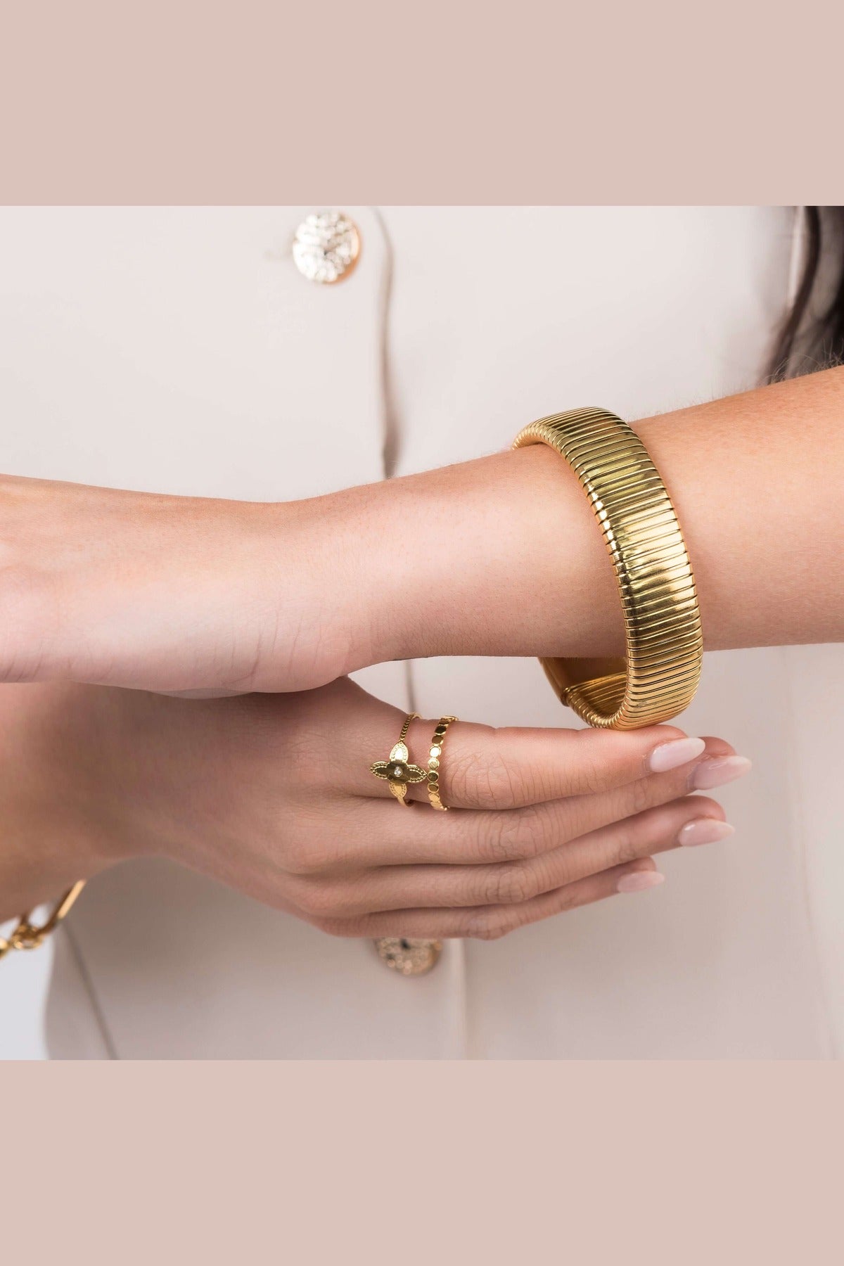 Close-up of Yasira Ribbed Wide Gold Bangle Bracelet and ring, showcasing modern jewelry design and elegance.