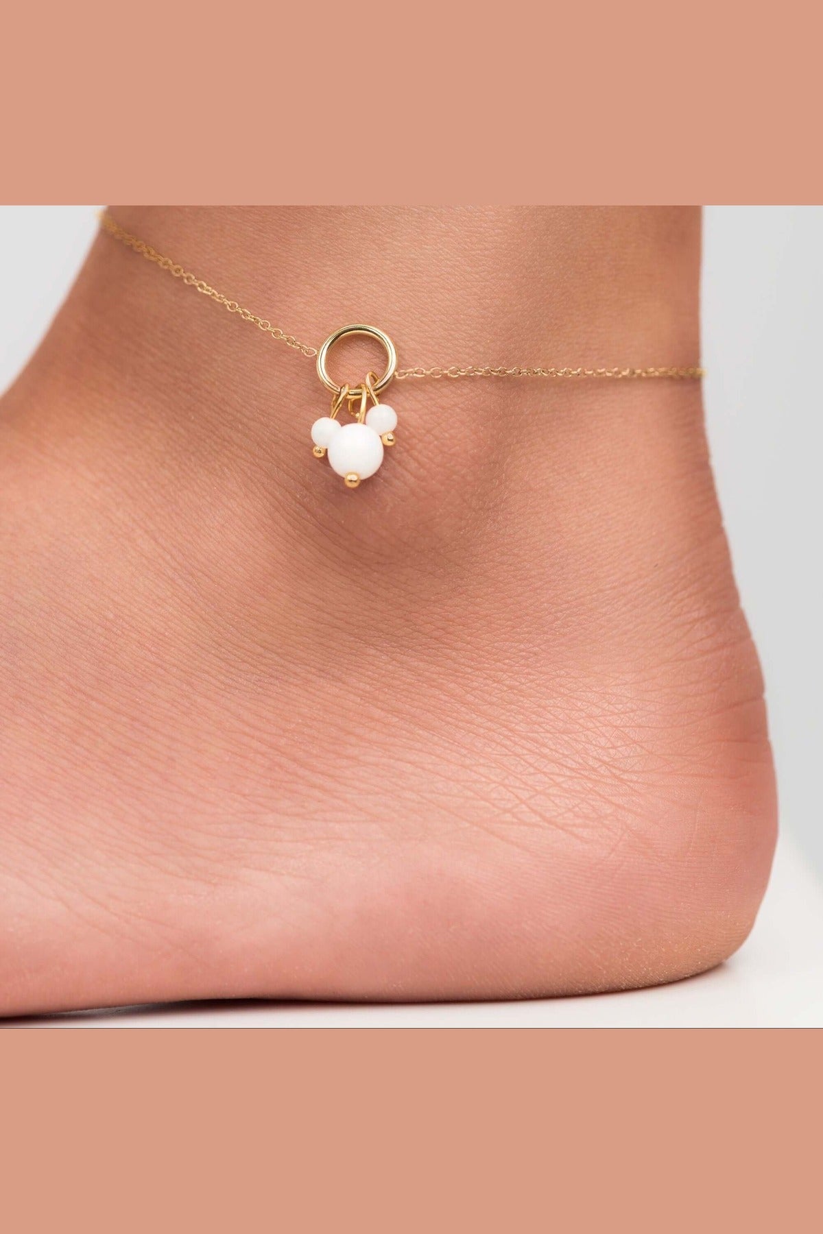 Close-up of Freya Delicate Pearl Charm Anklet with gold-plated chain and pearl-like beads on an ankle.